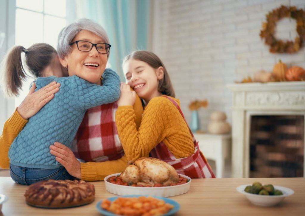 Woman hugging grandchildren at Thanksgiving dinner