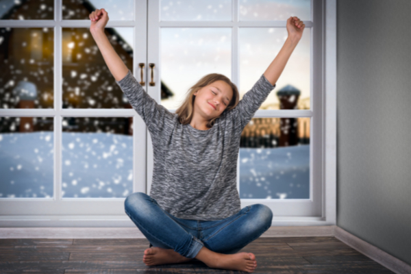 smiling girl stretching in front of the window