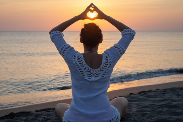 woman practicing yoga on the beach