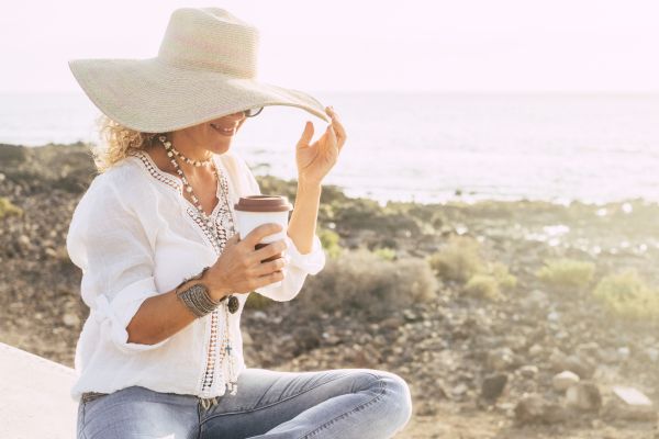woman drinking coffee at the beach